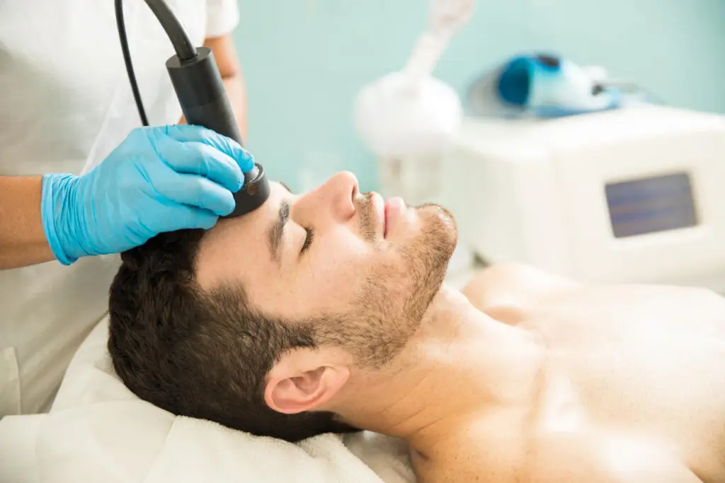 profile-view-good-looking-young-man-getting-rf-facial-treatment-health-spa